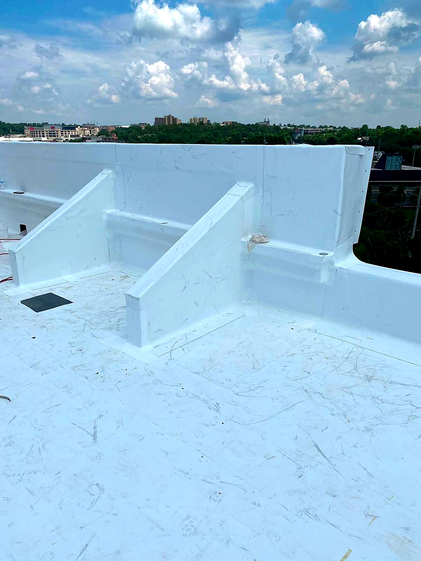 White membrane wrapped cleanly around parapet walls and a scupper