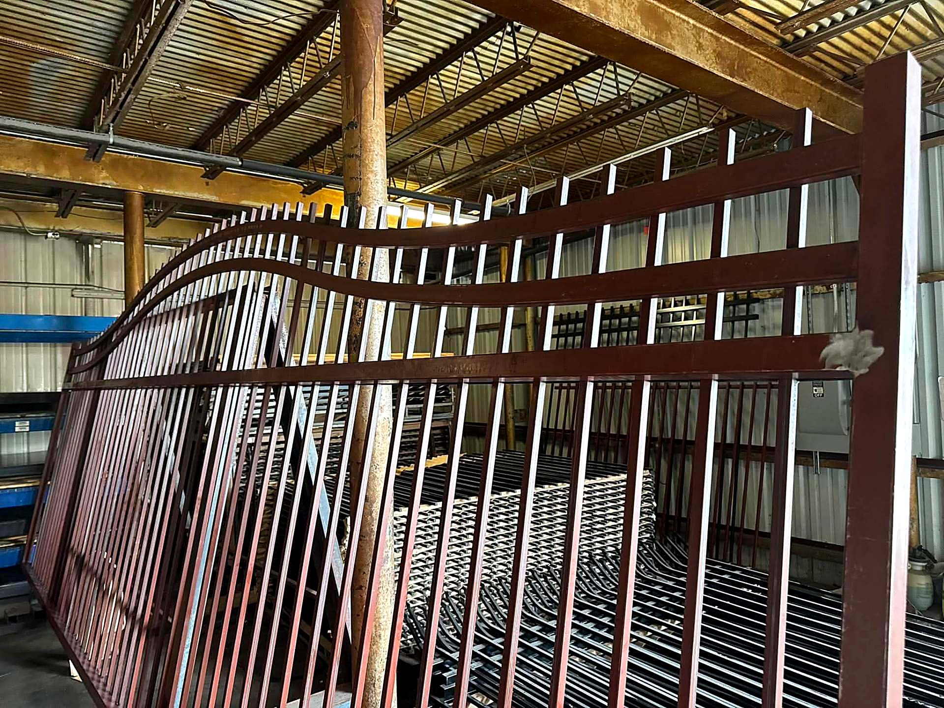 Large steel gates in primer stacked inside the fabrication shop
