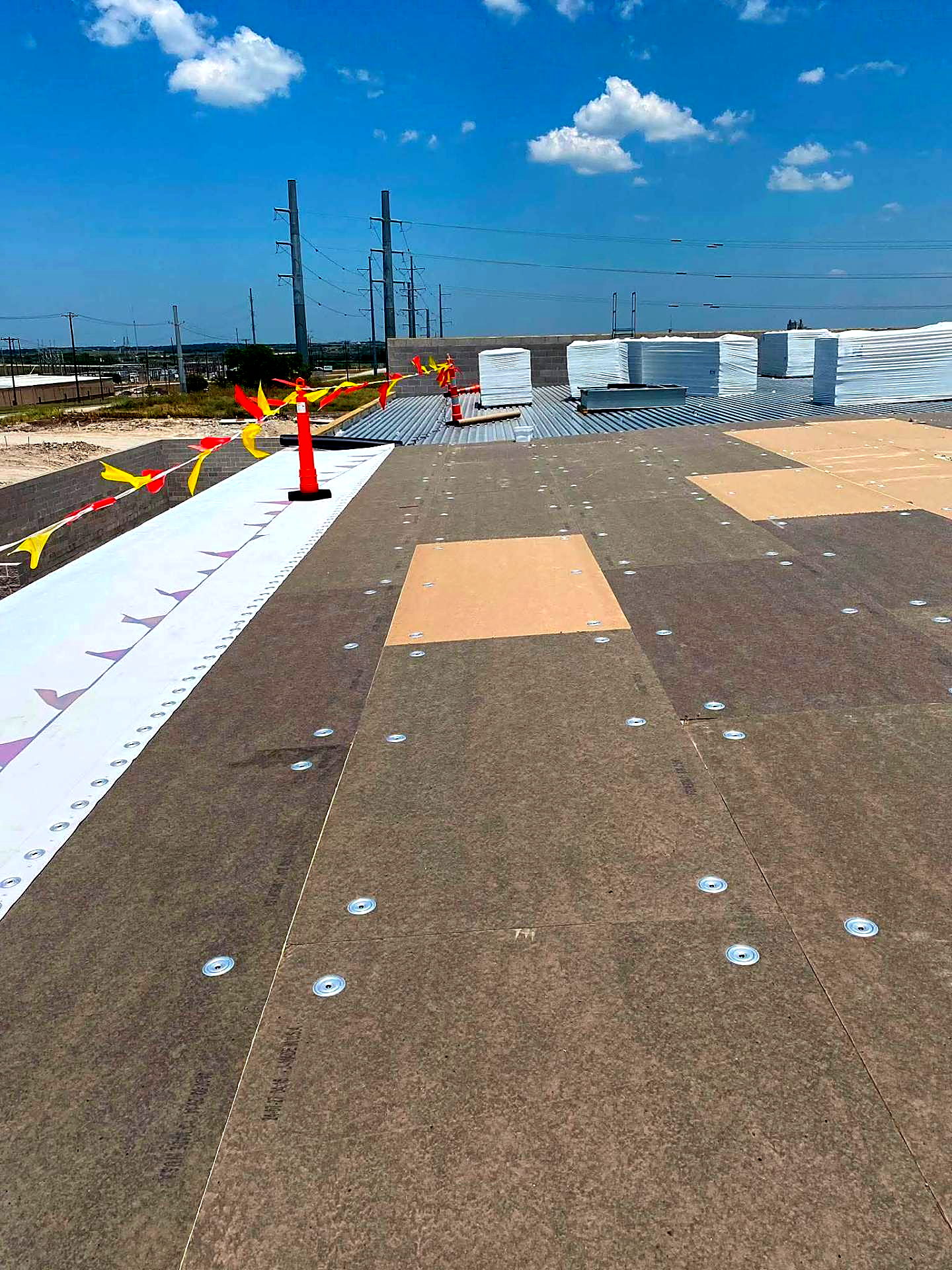 Wide view of membrane edge detail and fastened deck on a commercial build