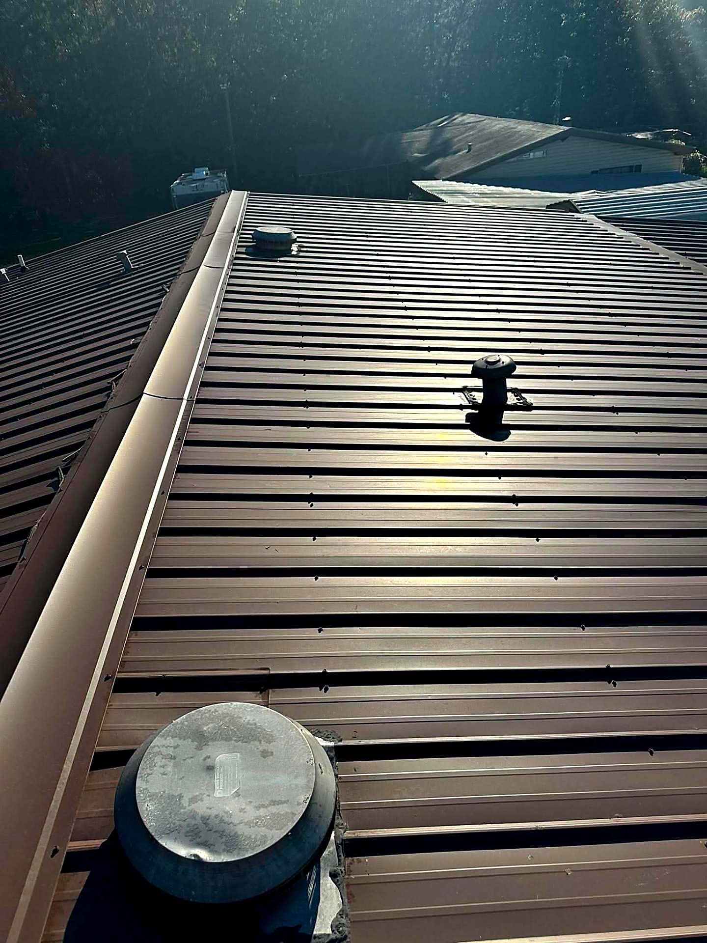 Brown metal roof panels with roof vents and boots sealed in