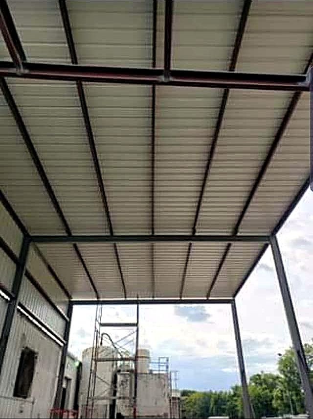 Underside of a steel canopy showing red painted beams and white roof decking
