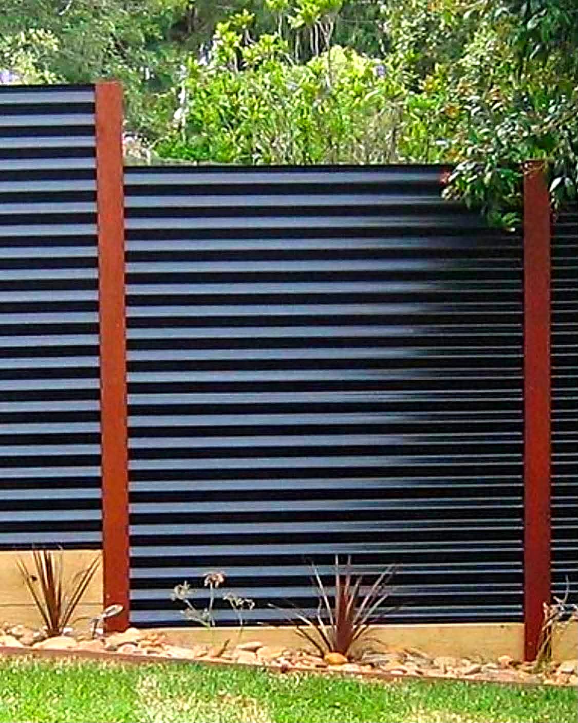 Corrugated metal privacy panels set between steel posts