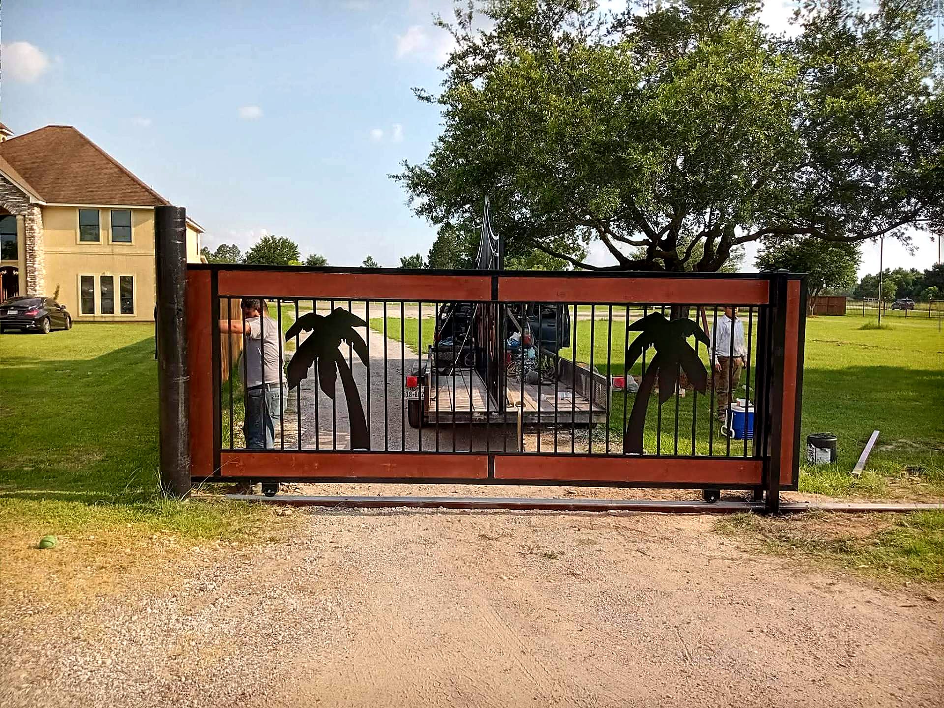 Rolling driveway gate with plasma-cut palm tree designs