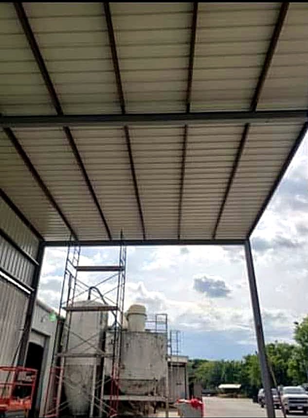 Underside of a steel canopy over a shop yard showing purlins and roof decking