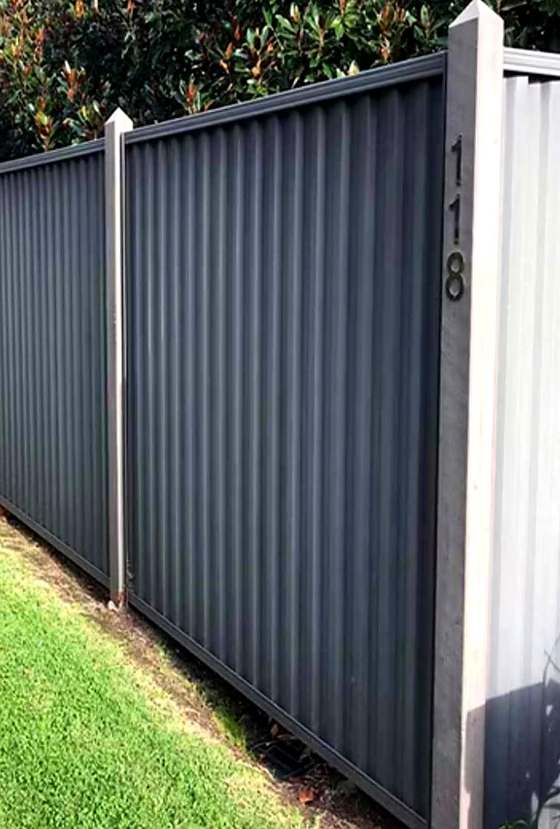 Grey metal fence panel and gate with capped posts